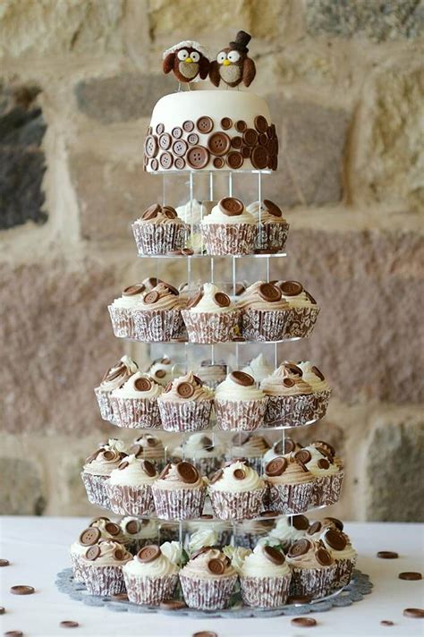 Servierte mehrstöckige Hochzeitstorte mit dekorierten Cupcakes und Gastgeschenken