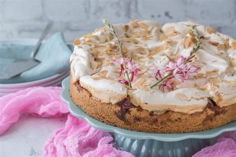 Servierter Rhabarberkuchen mit Sahne und Biskuit auf Kuchenteller