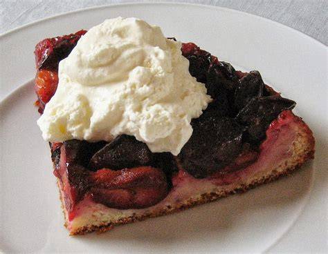 Serviertes Stück Zwetschgenkuchen mit Sahne