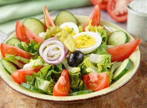 Serviertipps: Tsatsiki, Oliven, Brot und gemischter Salat neben Feta-Päckchen