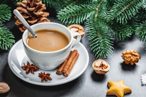 Serviervorschlag: Apfelkuchenstück auf Teller, daneben Tasse Kaffee, Winterdeko mit Tannenzweigen