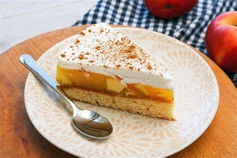 Serviervorschlag: Apfelkuchenstück mit Sahne und Zimt, dazu Apfelsaft