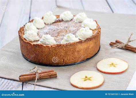 Serviervorschlag: Apfelkuchenstück mit Schlagsahne und Zimt