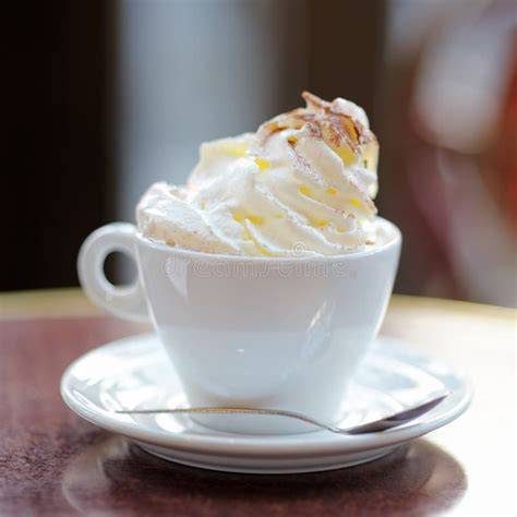 Serviervorschlag: Apfelkuchenstück mit Schlagsahne und einer Tasse Kaffee auf dem Holztisch