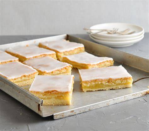 Serviervorschlag: Apfelmuskuchen mit Zuckerguss, Stücke auf Teller, Puderzucker