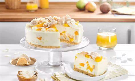 Serviervorschlag: Batida de Coco Torte mit Kokoschips und Mangospalten
