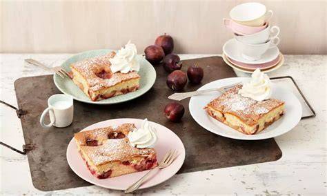 Serviervorschlag: Biskuitkuchen mit Pflaumen, Sahnetupfen, Zimt und Puderzucker