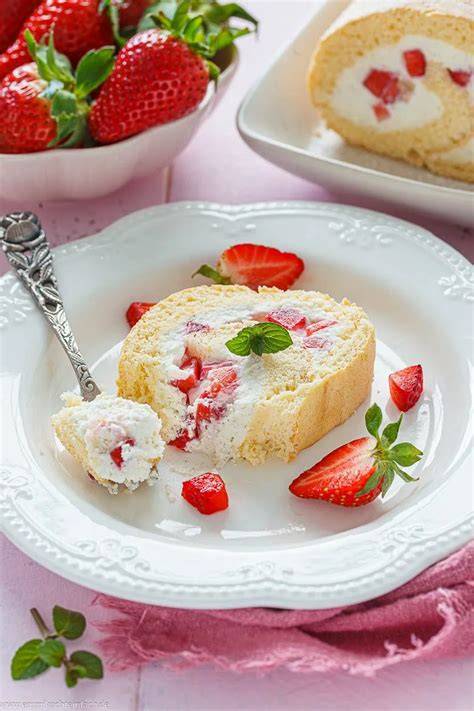 Serviervorschlag: Biskuitrolle mit Frischkäsefüllung, Erdbeeren und Minze