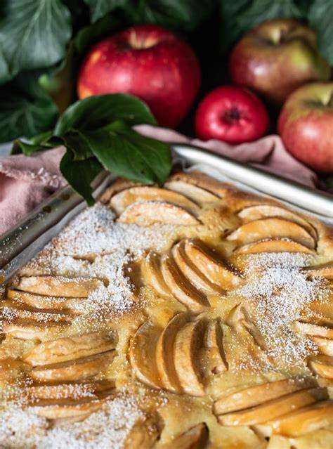 Serviervorschlag: Blechkuchen-Stück mit Schmandguss, Puderzucker und frischer Nektarine