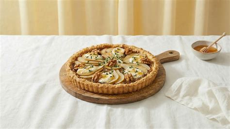 Serviervorschlag: Brokkoli-Blätterteig-Torte mit Kräutern, Nüssen und Honig auf Holzbrett