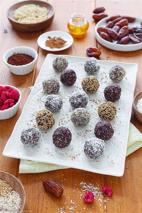 Serviervorschlag: Bunte Energy Balls auf einer Platte mit Obst
