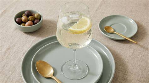 Serviervorschlag: Dessertglas auf Teller, daneben Glas Prosecco mit Zitronenscheibe
