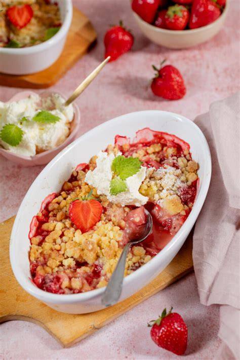 Serviervorschlag: Erdbeer-Crumble in Schälchen mit Puderzucker und Cappuccino