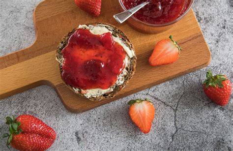 Serviervorschlag: Erdbeeraufstrich auf Brötchen, daneben Zitronen und Agar-Agar