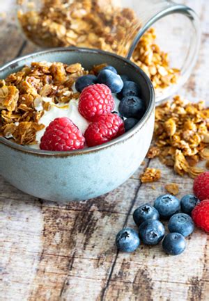 Serviervorschlag: Granola mit Joghurt und frischen Beeren in einer Schale
