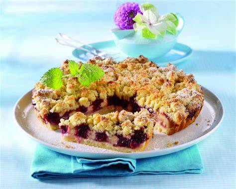 Serviervorschlag: Jostabeeren-Streuselkuchen mit Puderzucker und Minze