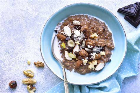Serviervorschlag: Kakao-Porridge zum Frühstück mit Beeren, Nüssen und Schokolade