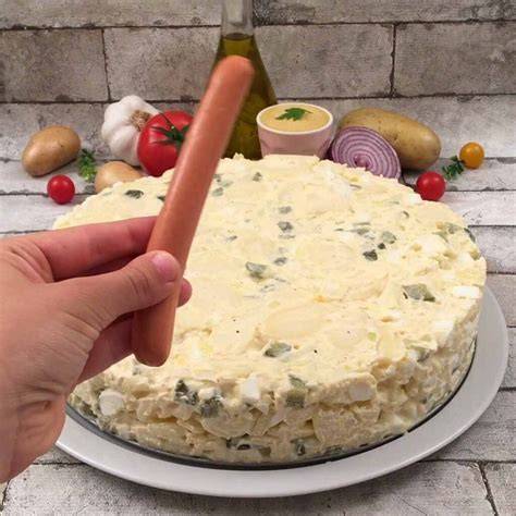 Serviervorschlag: Kartoffelsalat-Torte auf Tortenplatte, Schälchen Senf, aufgeschnittene Wiener