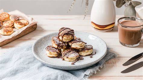 Serviervorschlag: Kuchenstück mit Puderzucker, Sahnetupf und heißem Kakao