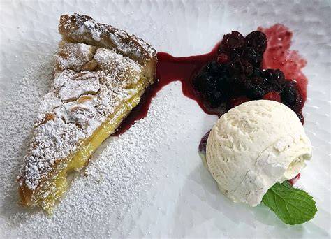 Serviervorschlag: Kuchenstück mit Vanilleeis und Beerenkompott