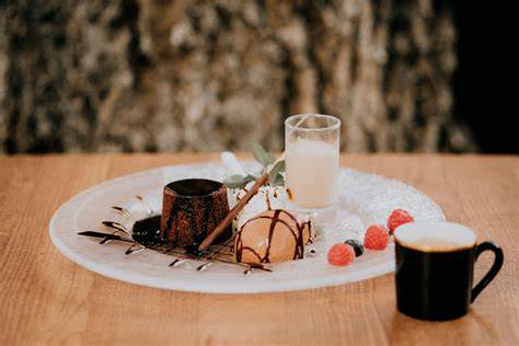 Serviervorschlag: Mini Pralinés mit Espresso und Dessertteller auf festlicher Tafel