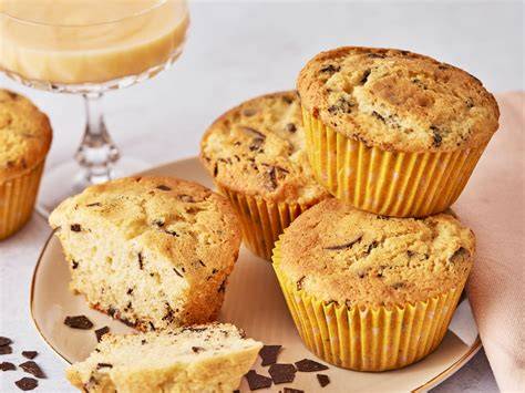 Serviervorschlag: Muffins im Papierförmchen, Glas Milch, Kaffeetasse, Streusel-Deko