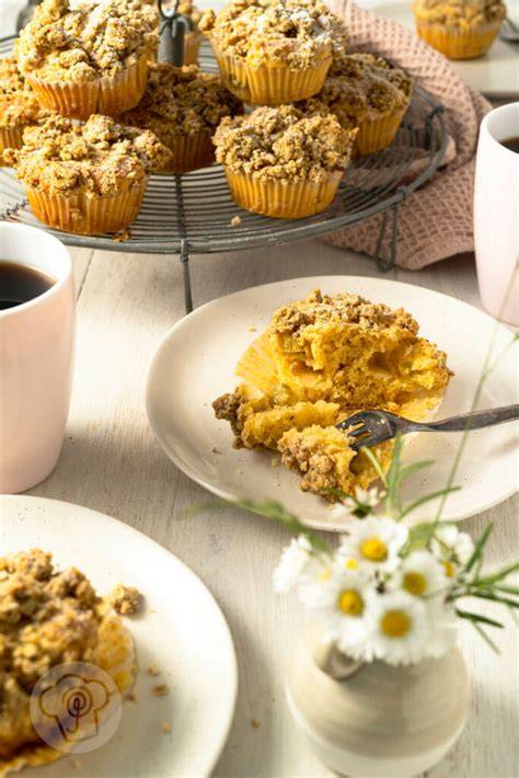 Serviervorschlag: Muffins mit Streuseln auf Teller, Kaffee daneben