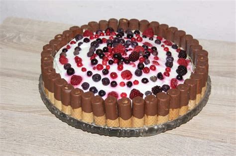 Serviervorschlag: Nougat-Torte mit Waffelröllchen und Krokant-Tupfen