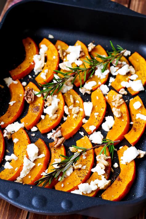 Serviervorschlag: Ofenkürbis mit Feta, Walnüssen, Rosmarin und Honig auf rustikalem Holzbrett