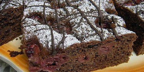 Serviervorschlag: Quark-Sahne-Kuchen mit Rosetten und Kakao bestäubt