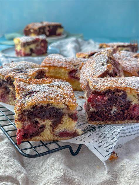 Serviervorschlag: Quarkkuchen-Stück mit Puderzucker und Kirschen