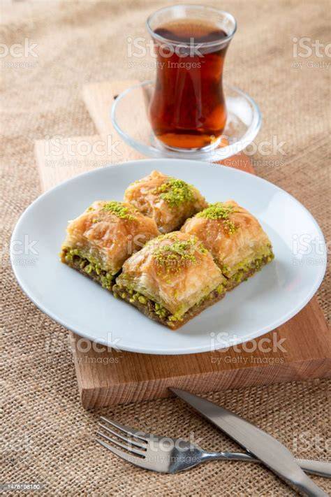 Serviervorschlag: Stück Baklava-Käsekuchen mit türkischem Tee und Pistazien