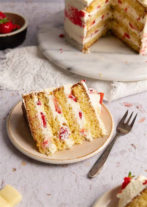 Serviervorschlag: Stück Erdbeer-Mascarpone-Torte auf Teller mit Holunder-Drip