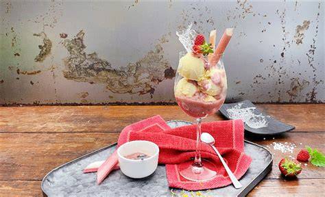 Serviervorschlag: Stück Erdbeer-Rhabarber-Pudding-Blechkuchen mit Vanilleeis