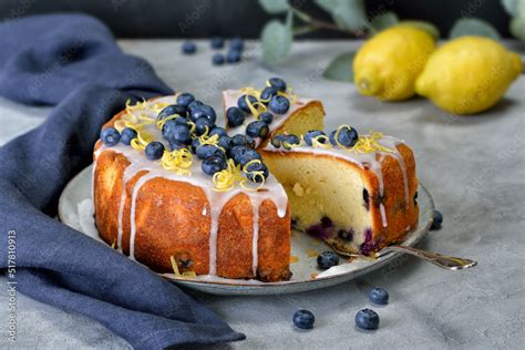 Serviervorschlag: Stück Heidelbeer-Rührkuchen mit Zitronenzesten und frischen Beeren