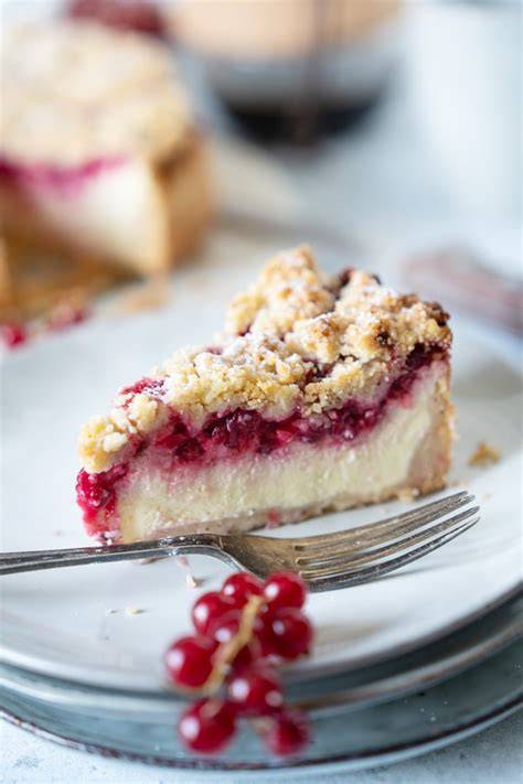 Serviervorschlag: Stück Johannisbeer-Käsekuchen auf Tortenplatte, Puderzucker, frische Beeren