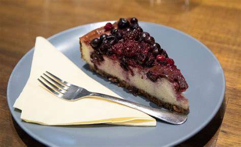 Serviervorschlag: Stück Käsekuchen auf Teller mit Beeren