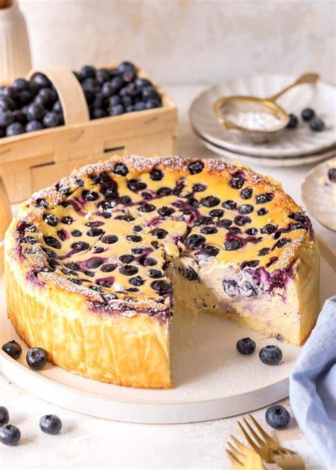 Serviervorschlag: Stück Käsekuchen ohne Boden mit Heidelbeeren, Minze und Puderzucker