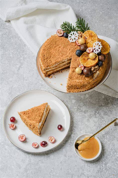 Serviervorschlag: Stück Karamell-Haselnuss-Torte auf Teller mit gerösteten Nüssen