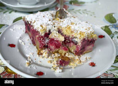 Serviervorschlag: Stück Kirsch-Pudding-Kuchen mit Puderzucker und Kaffee