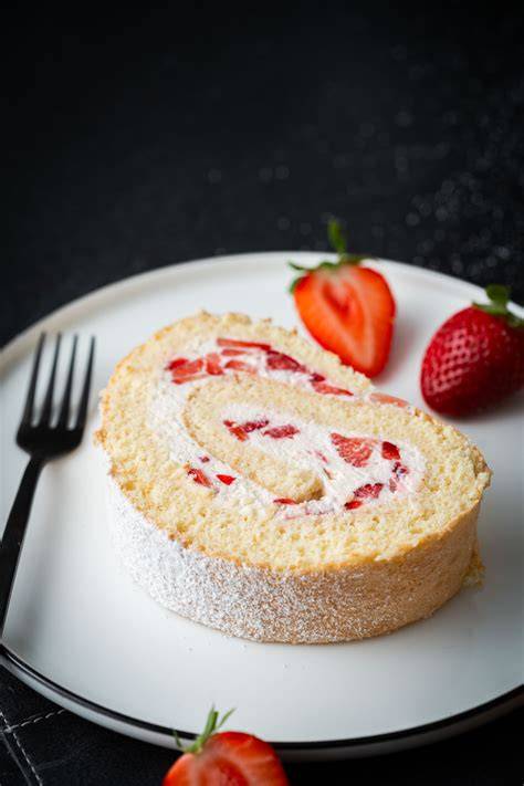 Serviervorschlag: Stück Kuchen auf Teller mit frischen Erdbeeren