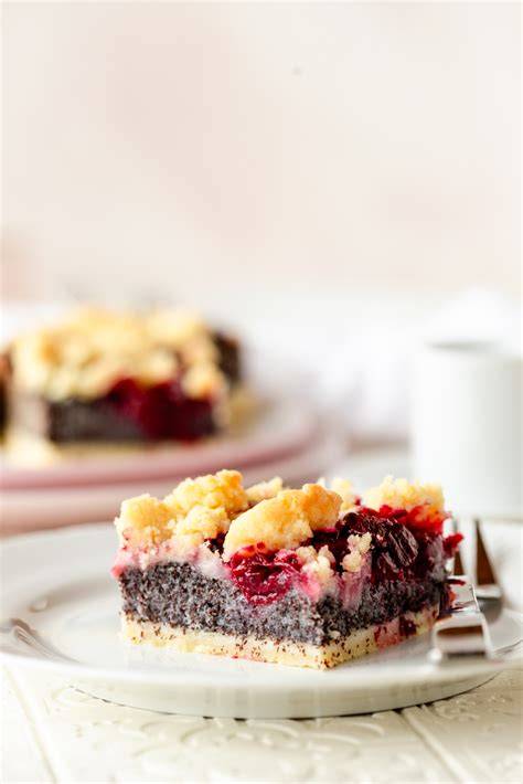 Serviervorschlag: Stück Mohn-Kirsch-Kuchen mit Schokoraspeln und Sahnetupfen