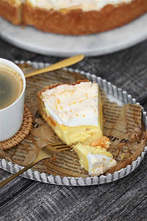 Serviervorschlag: Stück Vanille-Käsekuchen mit Baiser und Kaffee