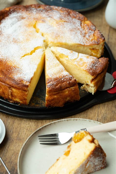 Serviervorschlag: Stücke Käsekuchen ohne Boden auf Platte, dazu Beerenkompott und Zitronenscheiben