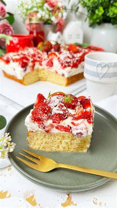 Serviervorschlag: Stücke Schmandcremetorte mit Erdbeeren auf einer weißen Platte