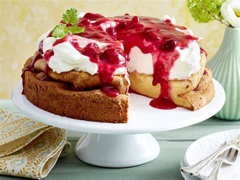 Serviervorschlag: Stücke der Rote-Grütze-Torte auf Tellern mit Beeren-Deko