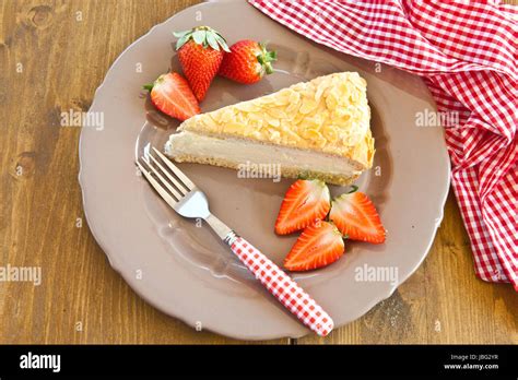 Serviervorschlag: Stücke der Torte auf Tellern mit frischen Erdbeeren