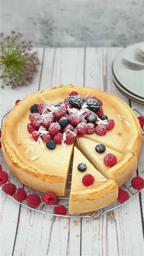 Serviervorschlag: Zitronen-Käsekuchen mit Beeren, Zitronenzesten und Puderzucker