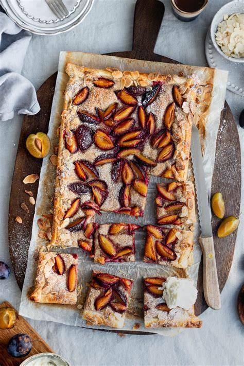 Serviervorschlag: Zwetschgenkuchen-Stücke mit Zimt-Zucker und Mandelblättchen