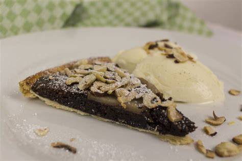 Serviervorschlag: warme Tarte mit Vanilleeis und Sahne auf Teller